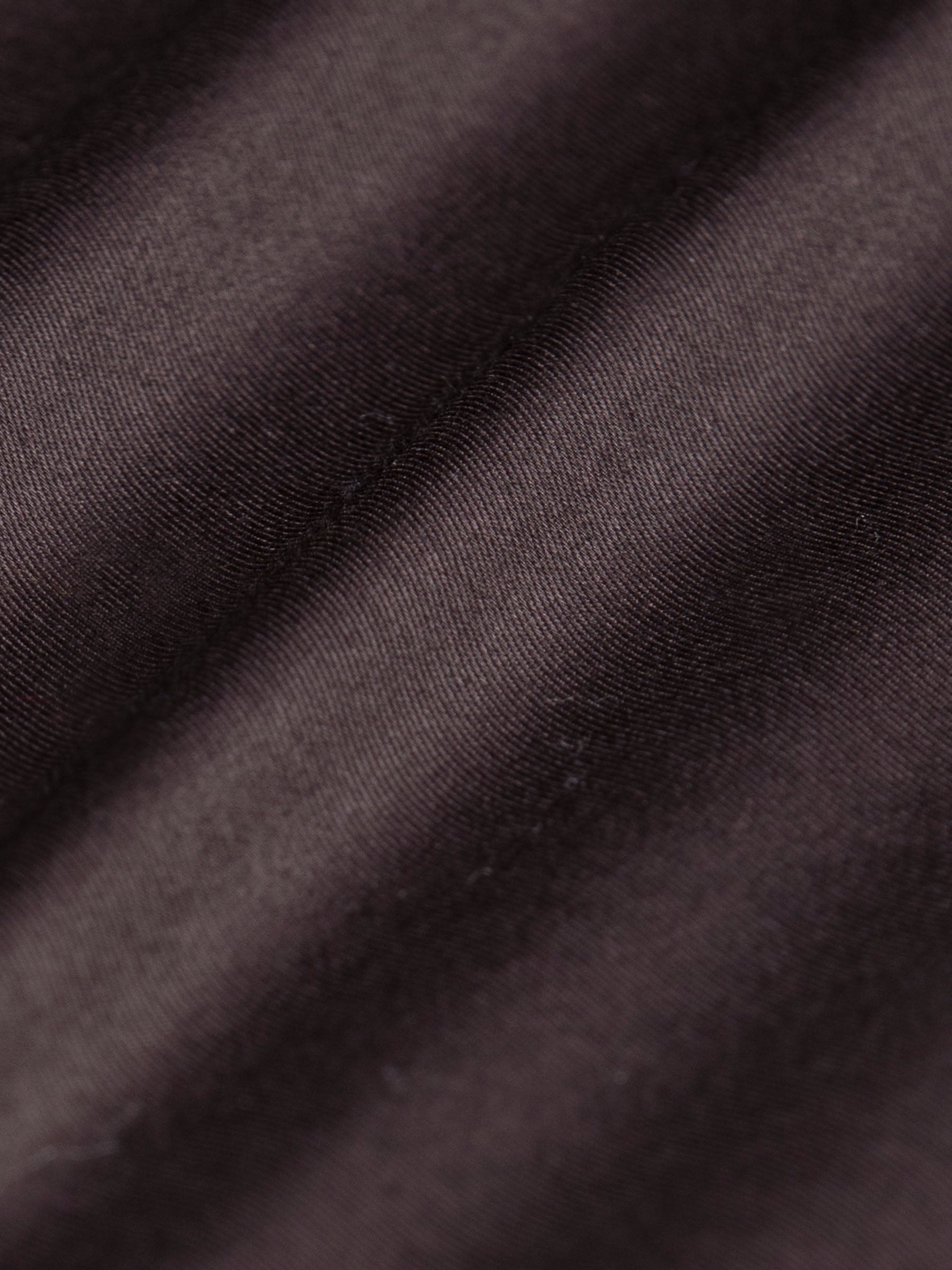 Close-up of brown shirt fabric texture with smooth cotton stretch finish