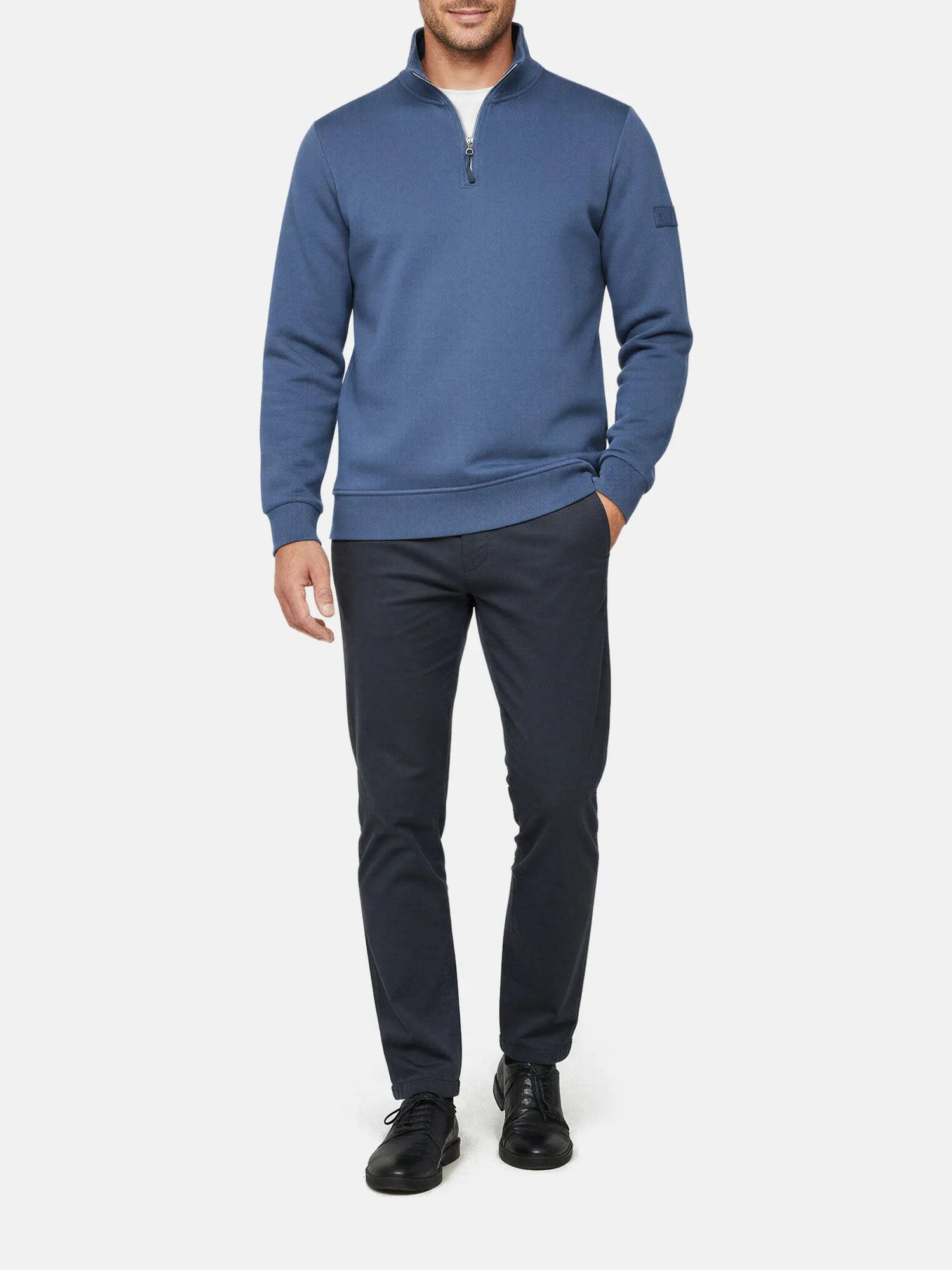 Model wearing  indigo quarter-zip men’s sweater with high collar, Prime Indigo style.