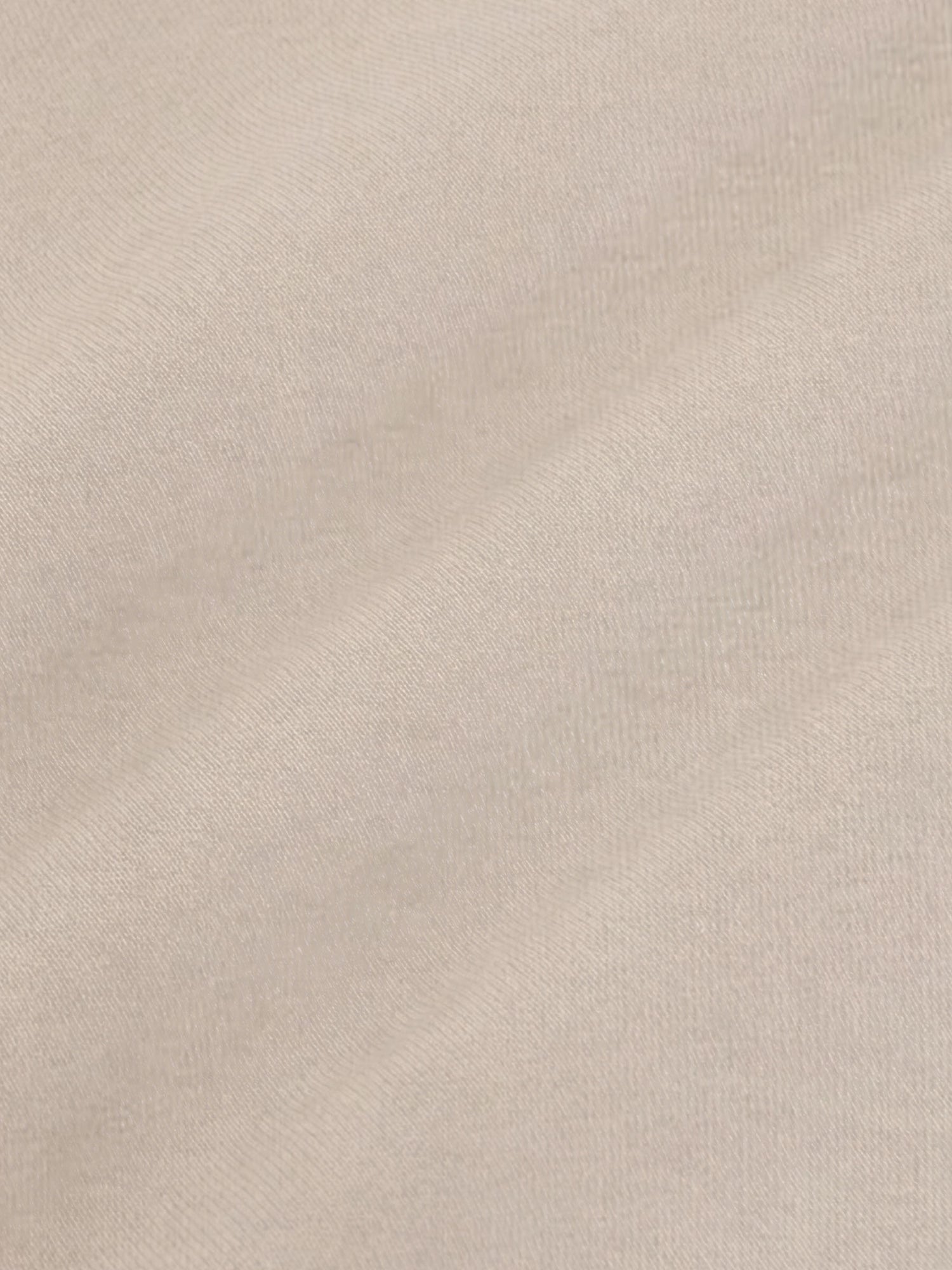 Close-up of beige blazer fabric showing smooth texture and refined weave