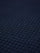 Close-up of indigo navy knit fabric showing dense textured waffle pattern.