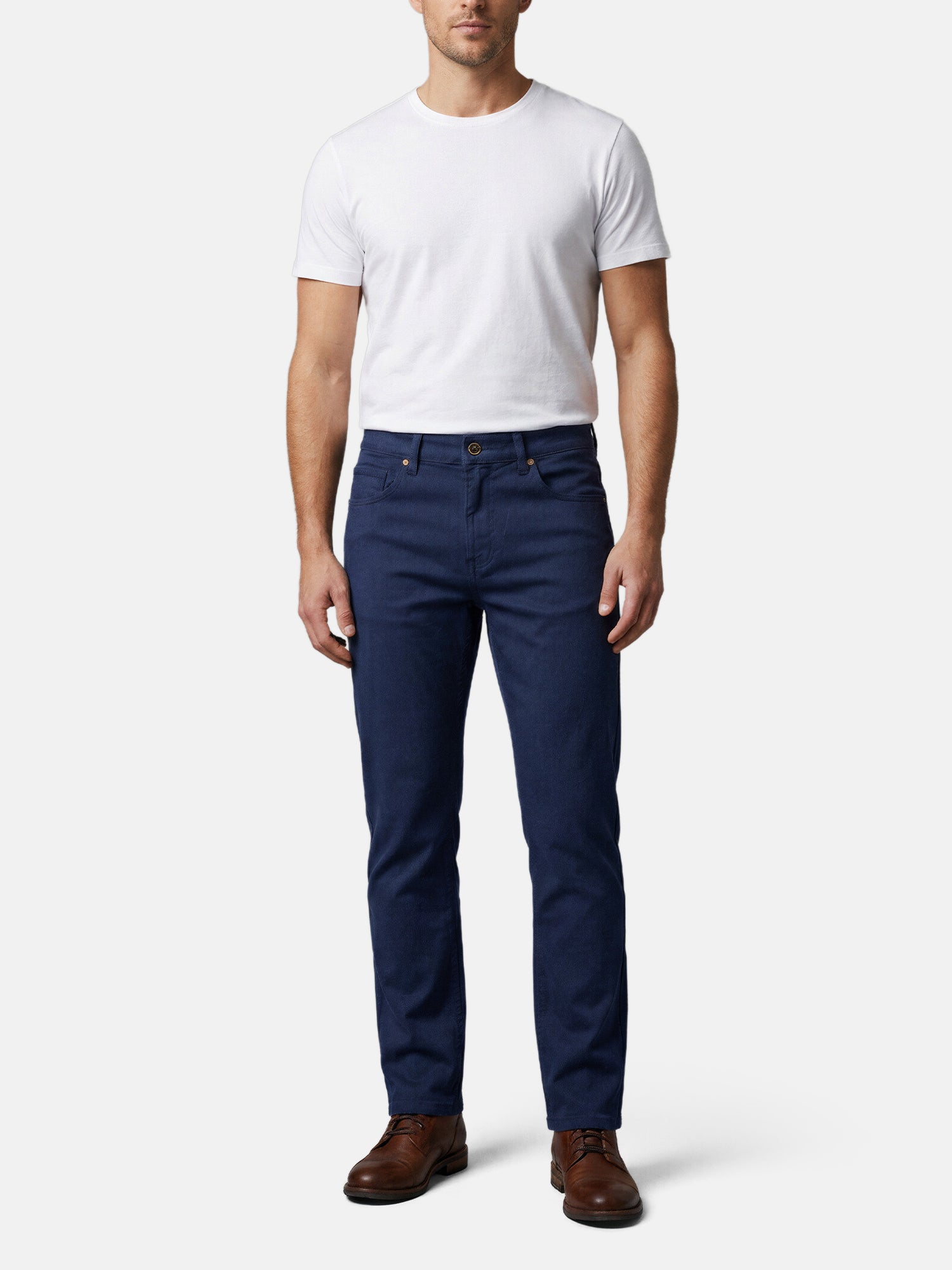 Men wearing navy slim-fit jeans styled with white T-shirt and brown leather shoes