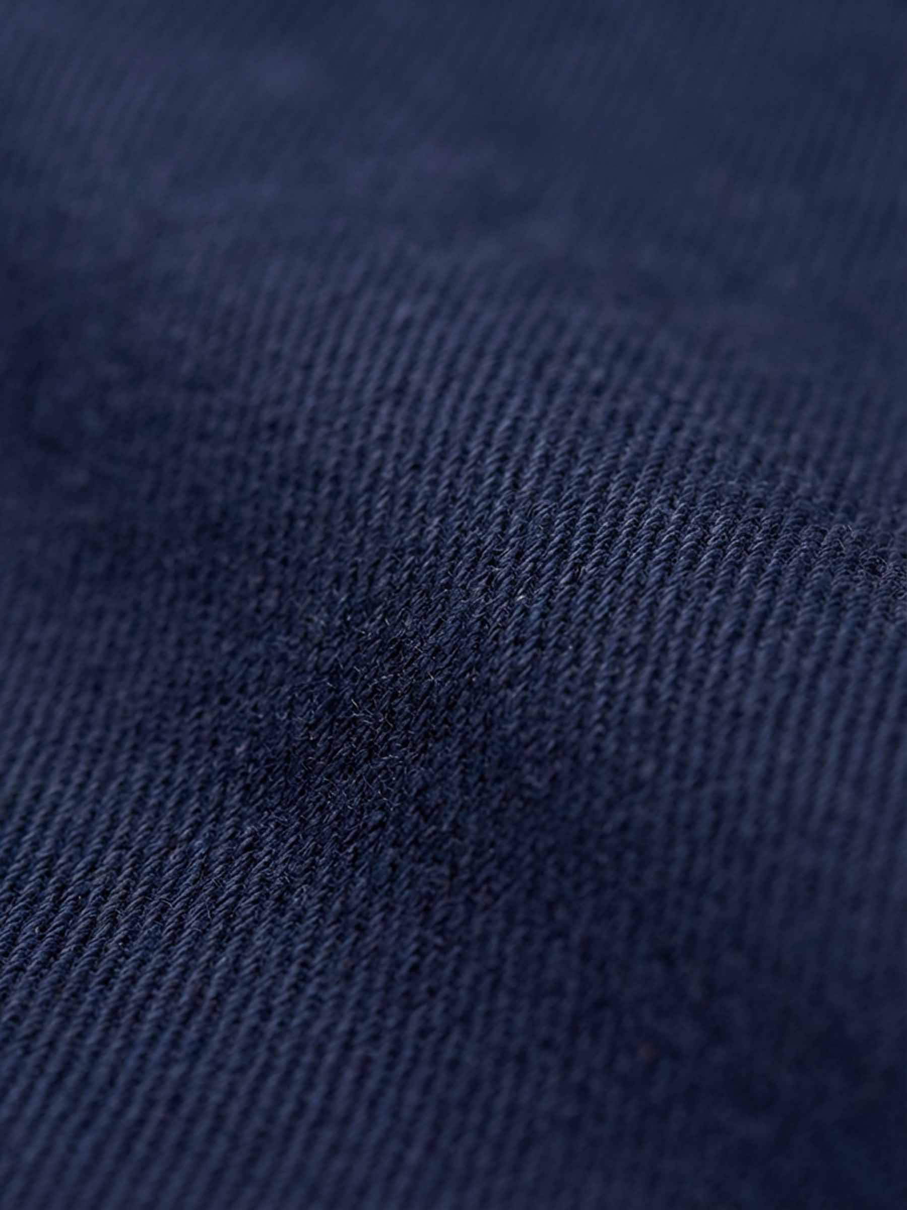 Close-up of navy denim fabric showing smooth weave and premium texture