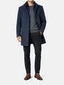Full-body view of a man wearing a light navy trenchcoat styled with dark trousers.