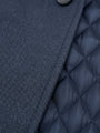 Close-up of light navy trenchcoat fabric showing textured outer weave and quilted inner lining.