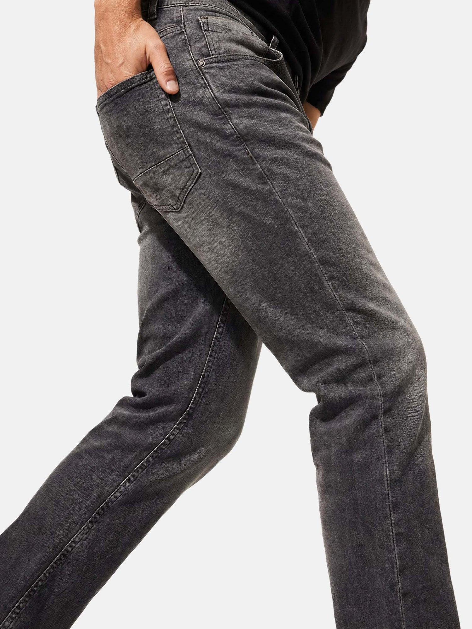 Close-up of grey slim fit jeans with faded wash and back pocket detail.