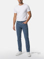 Model wearing slim fit blue men’s jeans with white t-shirt.