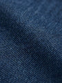 Close-up of blue denim fabric showing textured weave and durable finish