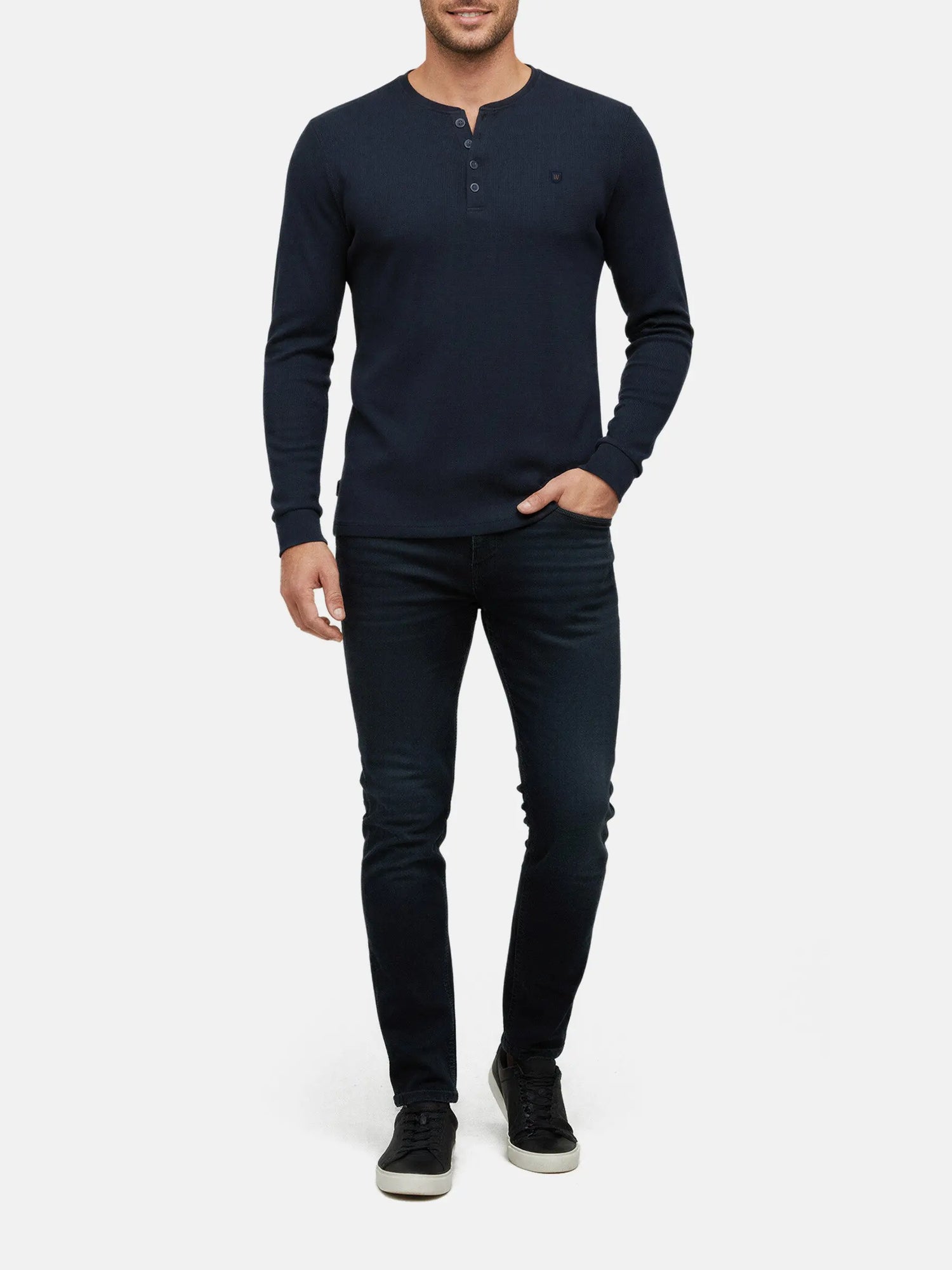 Model wearing navy long-sleeve men’s sweater with buttoned neckline, Zest Navy style.