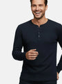 Close-up of model wearing navy long-sleeve Zest sweater with buttoned neckline.