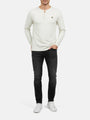 Model wearing off-white sweater with long sleeves, styled with dark jeans.